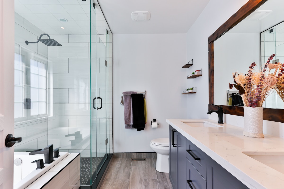 Bright bathroom remodel with modern tub, shower fixtures, vanity, and tile